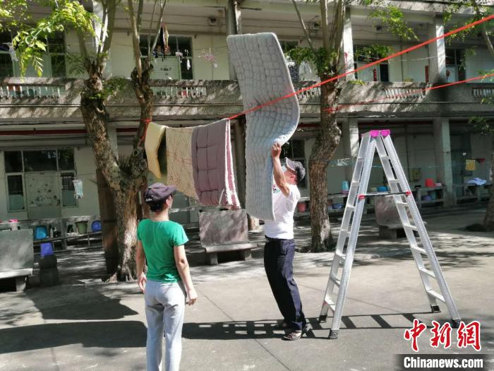 海南师范大学教师帮学生晒被子。海南大学供图 点击进入下一页